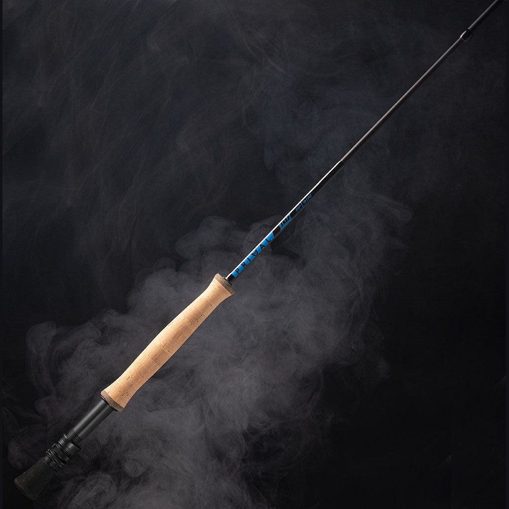 A Primal Blitz saltwater fly rod with a light colored handle and blue detailing, displayed with a smoky background.